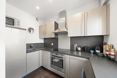 a kitchen with white cabinets and stainless steel appliances at Agréable studio à deux pas de la Croisette in Cannes