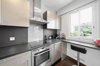 a kitchen with white cabinets and a stove top oven at Agréable studio à deux pas de la Croisette in Cannes