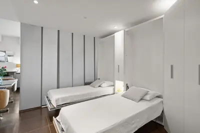 two beds in a room with white walls at Agréable studio à deux pas de la Croisette in Cannes