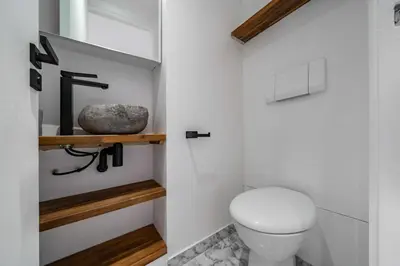 a bathroom with a toilet and a rock on a shelf at Superbe appartement 5 pièces sur la Croisette in Cannes