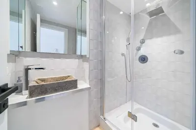 a bathroom with a glass shower with a sink and a tub at Superbe appartement 5 pièces sur la Croisette in Cannes