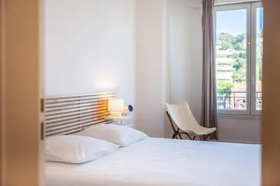 a bedroom with a white bed and a window at Superb two-bedroom near the Croisette in Cannes