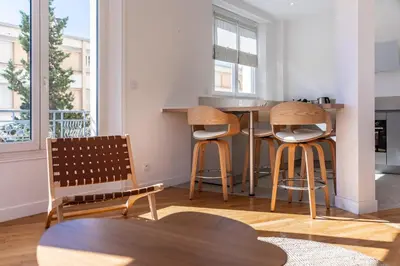 a kitchen with three bar stools and a table at Superb two-bedroom near the Croisette in Cannes