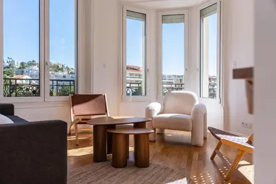 a living room with chairs and a table and windows at Superb two-bedroom near the Croisette in Cannes