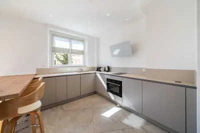 a kitchen with white cabinets and a sink and a window at Superb two-bedroom near the Croisette in Cannes