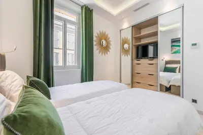 a bedroom with two beds and a mirror at Cozystay 1243 Port & Sea View Cannes in Cannes