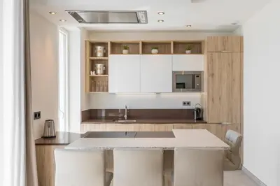 a kitchen with white cabinets and a table at Cozystay 1243 Port & Sea View Cannes in Cannes
