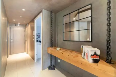 a hallway with a shelf with books and a window at Brand new 3 bedrooms heart of Cannes in Cannes