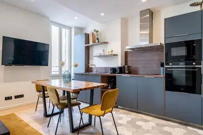 a kitchen with a wooden table and chairs at Pleasant 2 bedroom in the heart of Cannes in Cannes
