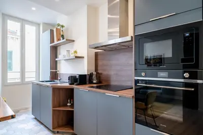 a kitchen with a black microwave and a counter at Pleasant 2 bedroom in the heart of Cannes in Cannes