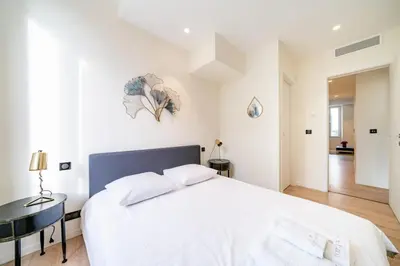 a white bedroom with a large bed and a desk at Pleasant 2 bedroom in the heart of Cannes in Cannes