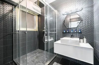 a bathroom with a sink and a glass shower at COZYSTAY - Brand new 3 bedrooms 2min walk to carlton hotel in Cannes