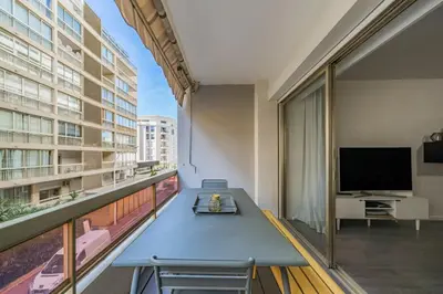 a living room with a table and a large window at COZYSTAY - Brand new 3 bedrooms 2min walk to carlton hotel in Cannes