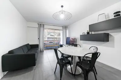 a living room with a table and a couch at COZYSTAY - Brand new 3 bedrooms 2min walk to carlton hotel in Cannes