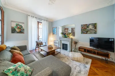 a living room with a couch and a tv at Cozystay 1225 Bourgeois Charm in Cannes Center in Cannes