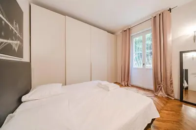 a white bed in a room with a window at Cozystay 1225 Bourgeois Charm in Cannes Center in Cannes