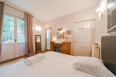 a bedroom with a large white bed and a bathroom at Cozystay 1225 Bourgeois Charm in Cannes Center in Cannes