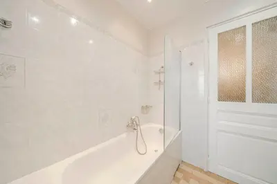 a white bathroom with a tub and a shower at Cozystay 1225 Bourgeois Charm in Cannes Center in Cannes