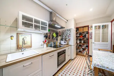 a kitchen with white cabinets and a sink and a refrigerator at Cozystay 1225 Bourgeois Charm in Cannes Center in Cannes