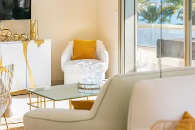 a living room with a chair and a table at Wonderful 2 bedroom facing the Croisette in Cannes