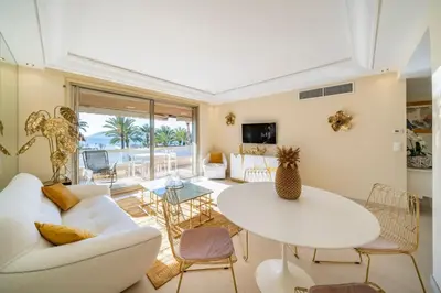 a living room with a white couch and a table at Wonderful 2 bedroom facing the Croisette in Cannes