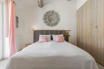 a bedroom with a large bed with pink pillows at Cozystay 1674 - Gorgeous sea view 3-bedroom duplex in Cannes