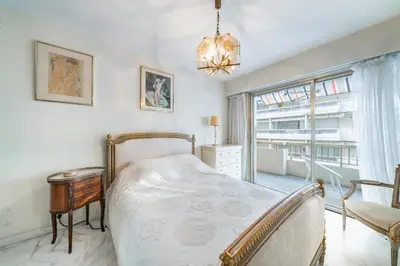 a bedroom with a bed and a chair and a window at Apartment for 4 people in the heart of Cannes in Cannes