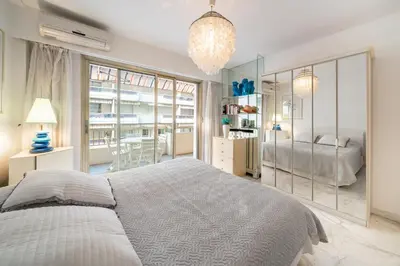 a bedroom with a large bed and a chandelier at Apartment for 4 people in the heart of Cannes in Cannes