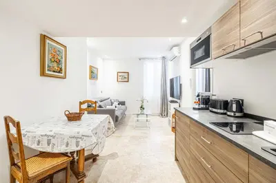 a kitchen and living room with a table and a couch at 84 MEY - Apartment for 4 people near Croisette and Palais in Cannes