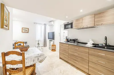 a kitchen with wooden cabinets and a table at 84 MEY - Apartment for 4 people near Croisette and Palais in Cannes