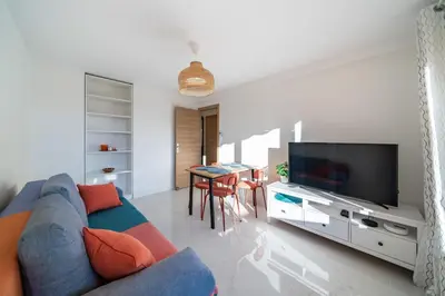 a living room with a blue couch and a tv at Agréable 3 pièces rénové à deux pas de la croisette in Cannes