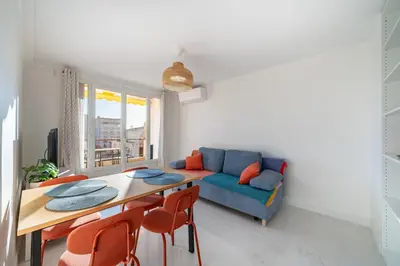 a living room with a blue couch and a table at Agréable 3 pièces rénové à deux pas de la croisette in Cannes