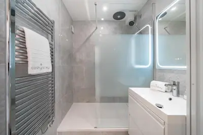 a white bathroom with a shower and a sink at Agréable 3 pièces rénové à deux pas de la croisette in Cannes