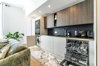 a kitchen with a washer and dryer next to a couch at Les Lucioles 7- Luxury 2 - Bedroom Apartment in Cannes