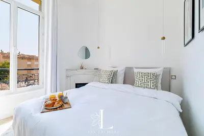 a white bedroom with a bed with a tray of food on it at Les Lucioles 7- Luxury 2 - Bedroom Apartment in Cannes