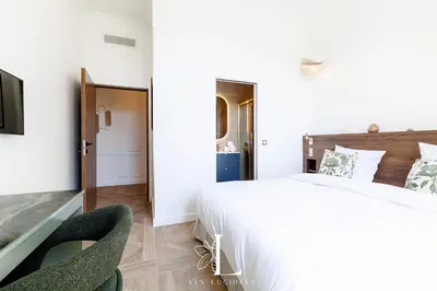 a bedroom with a large bed and two chairs at Les Lucioles 7- Luxury 2 - Bedroom Apartment in Cannes