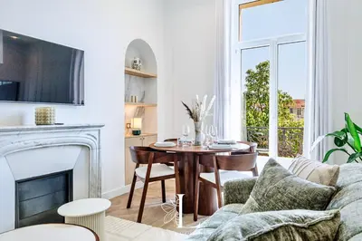 a living room with a table and a fireplace at Les Lucioles 7- Luxury 2 - Bedroom Apartment in Cannes
