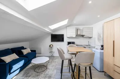 a living room with a blue couch and a table at Renovated and Bright Studio 3P - Cannes in Cannes