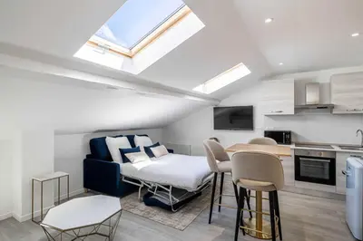 a kitchen and a living room with a bed and a table at Renovated and Bright Studio 3P - Cannes in Cannes