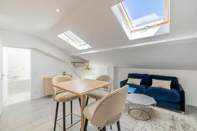 a room with a table and chairs and a blue couch at Renovated and Bright Studio 3P - Cannes in Cannes