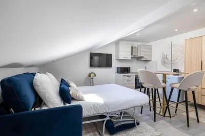 a living room with a bed and a kitchen at Renovated and Bright Studio 3P - Cannes in Cannes