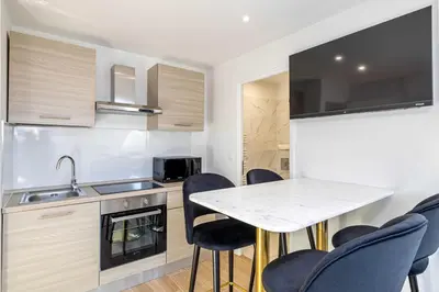 a kitchen with a table and chairs and a sink at Renovated and Bright Studio 4P - Cannes in Cannes