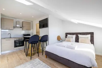 a bedroom with a large bed and a kitchen at Renovated and Bright Studio 4P - Cannes in Cannes