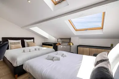 two beds in a attic room with a skylight at Renovated and Bright Studio 4P - Cannes in Cannes
