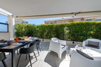a balcony with tables and chairs and a television at 3-Br Rooftop with Jacuzzi & Parking Cannes in Cannes