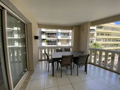 a dining room with a table and chairs on a balcony at Cannes Proche Croisette - Appartement 3 pièces in Cannes