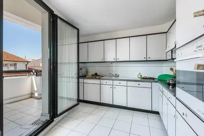 a kitchen with white cabinets and a large window at Appartement Cannes Hyper Centre in Cannes