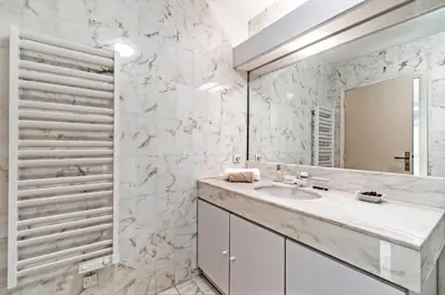 a white bathroom with a sink and a mirror at Appartement Cannes Hyper Centre in Cannes