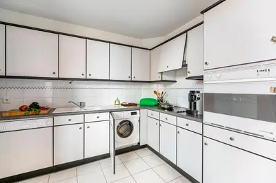 a white kitchen with white cabinets and a dishwasher at Appartement Cannes Hyper Centre in Cannes