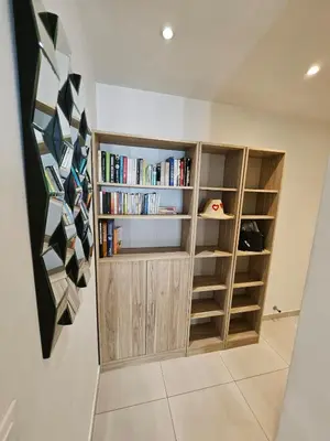 a library with wooden shelves and books at Appartement 2 pièces, emplacement de rêve Martinez in Cannes